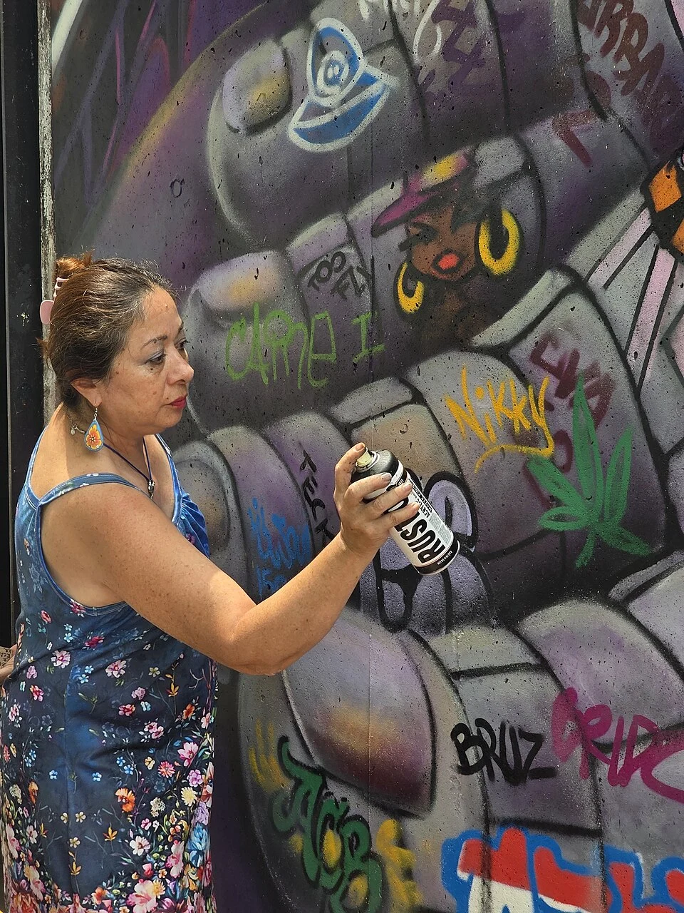 Lady Pink working on her mural at the entryway to MoMA PS1