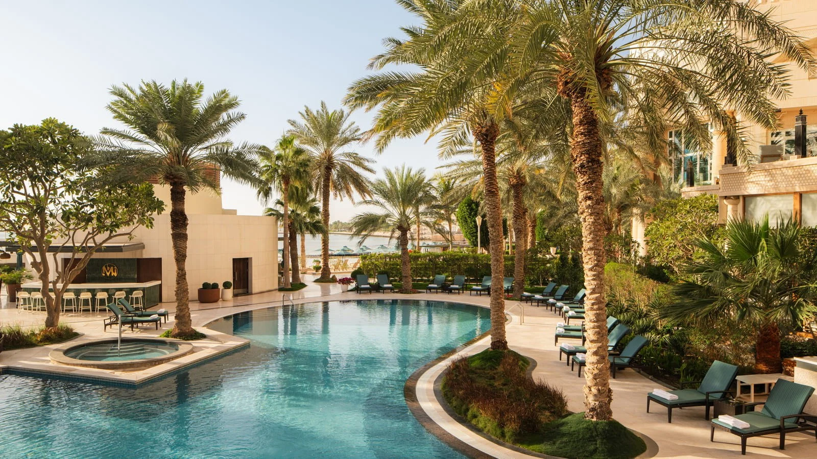 Palm-lined pools and the private beach at Four Seasons Hotel Doha