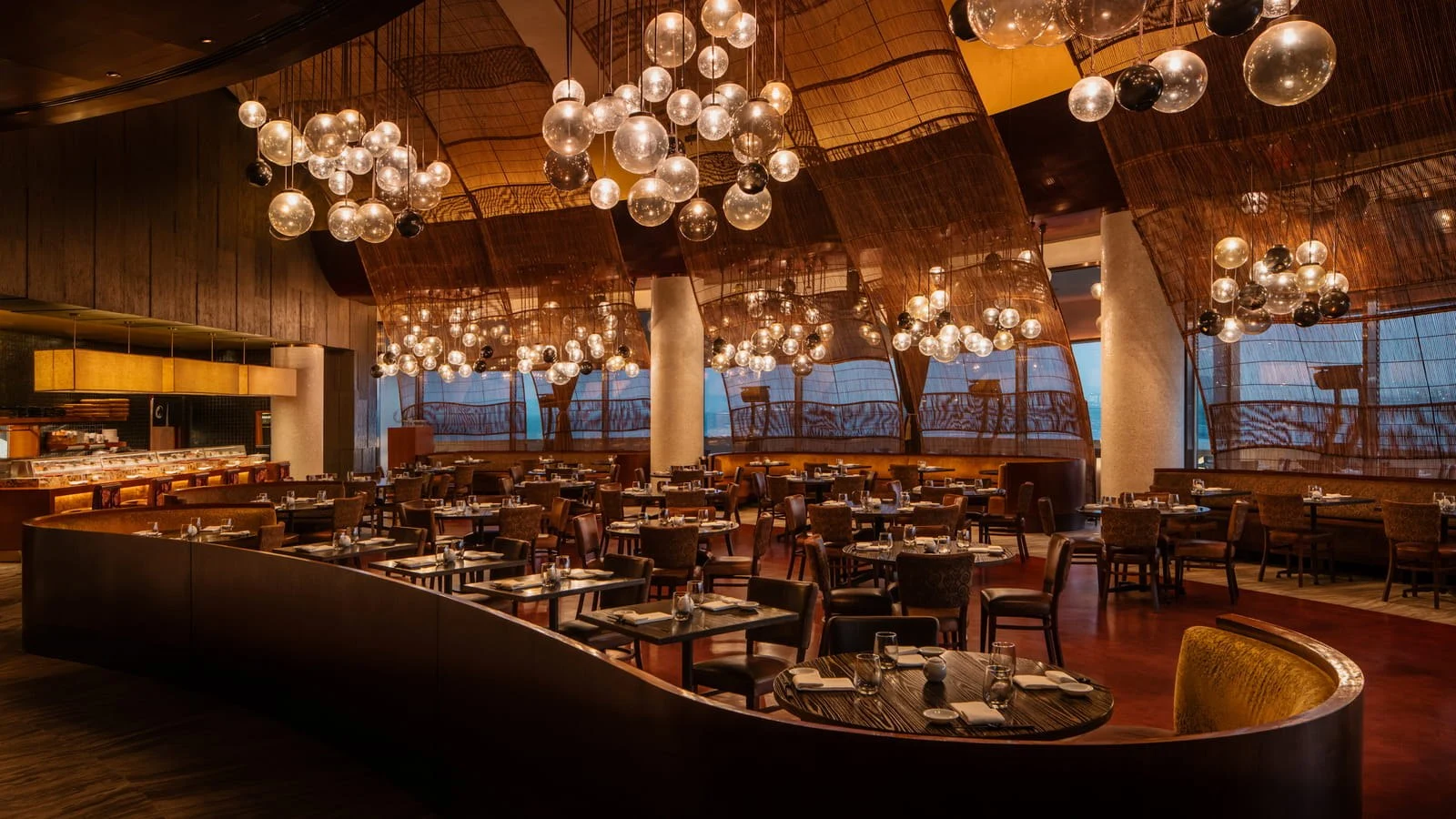 The warmly lit dining room at Nobu Doha